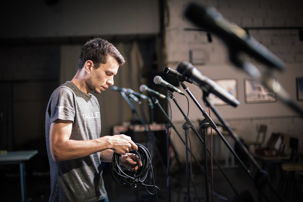 A Tallen AV technician sets up microphones for a live event